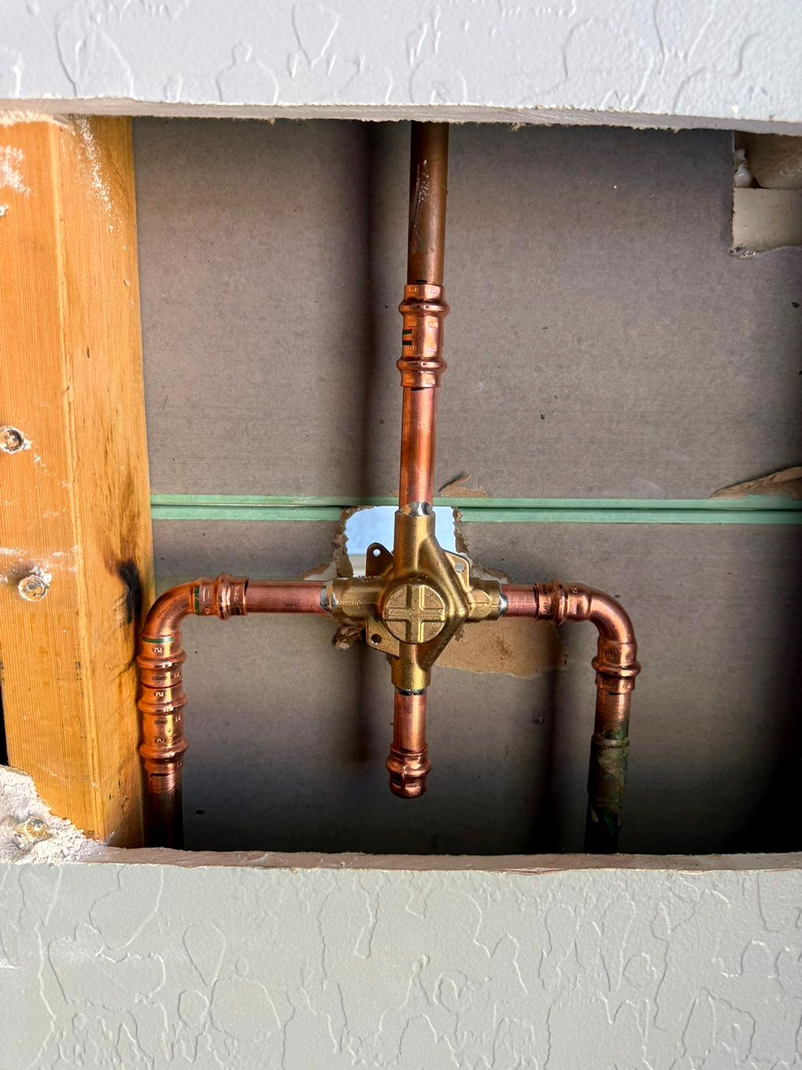 The new copper shower valve inside the wall before it closed up