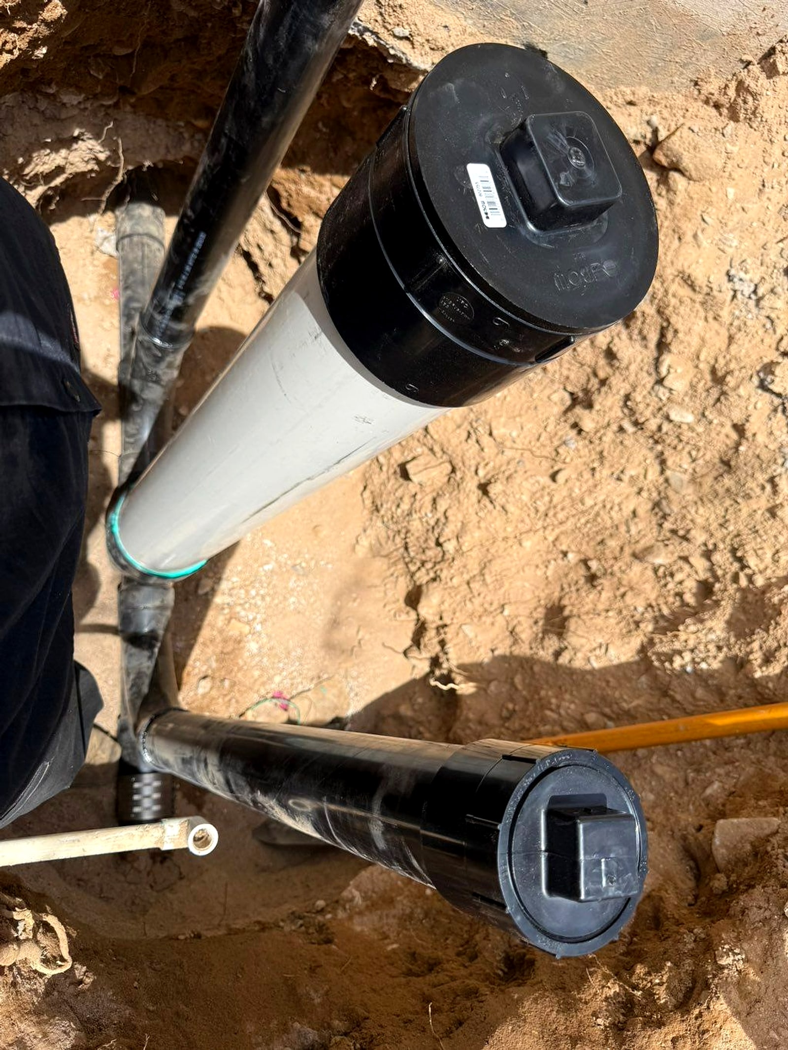 New sewer cleanout fitting and pipe set in sandy soil