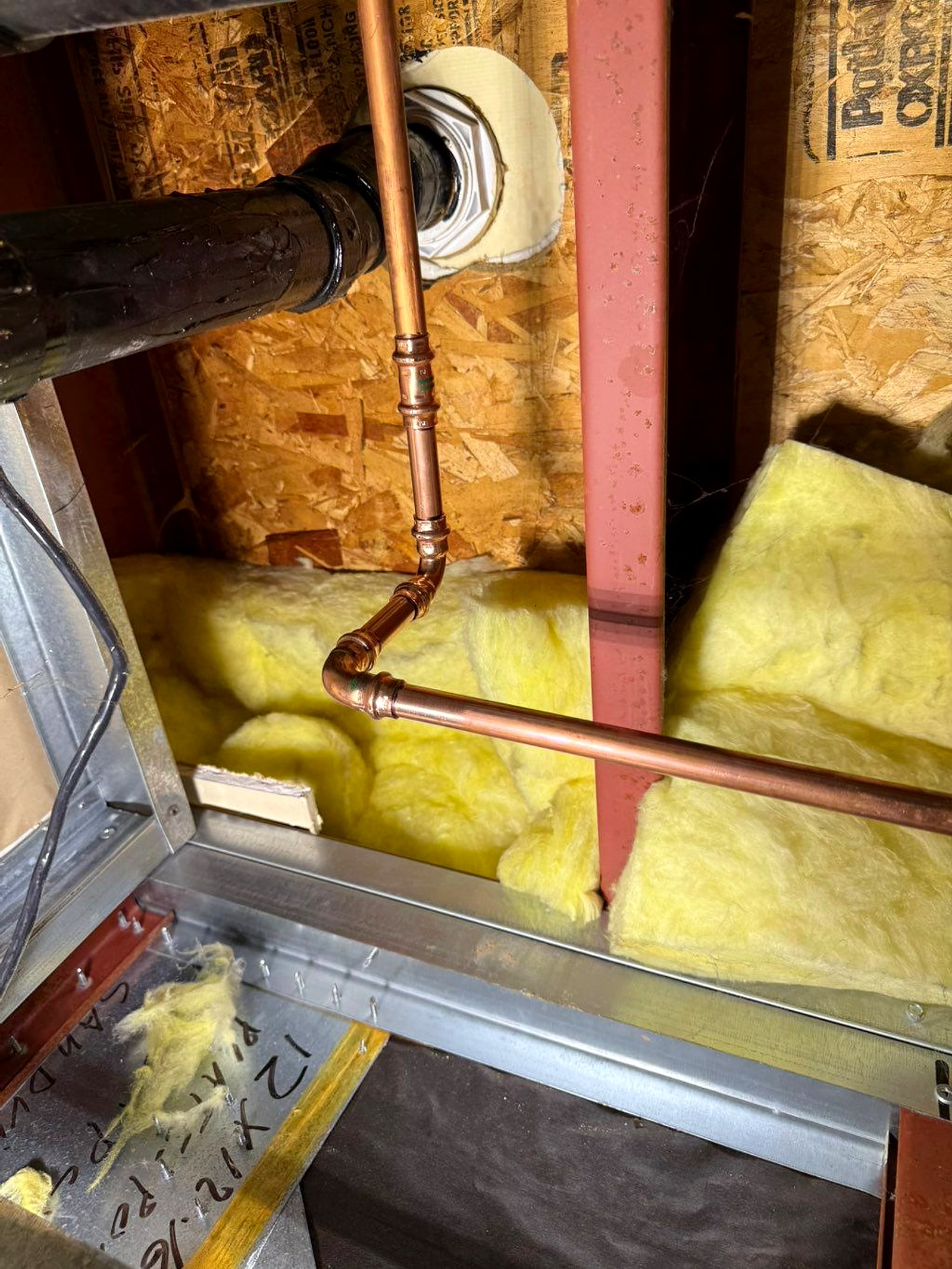 Copper water lines run through open wall framing