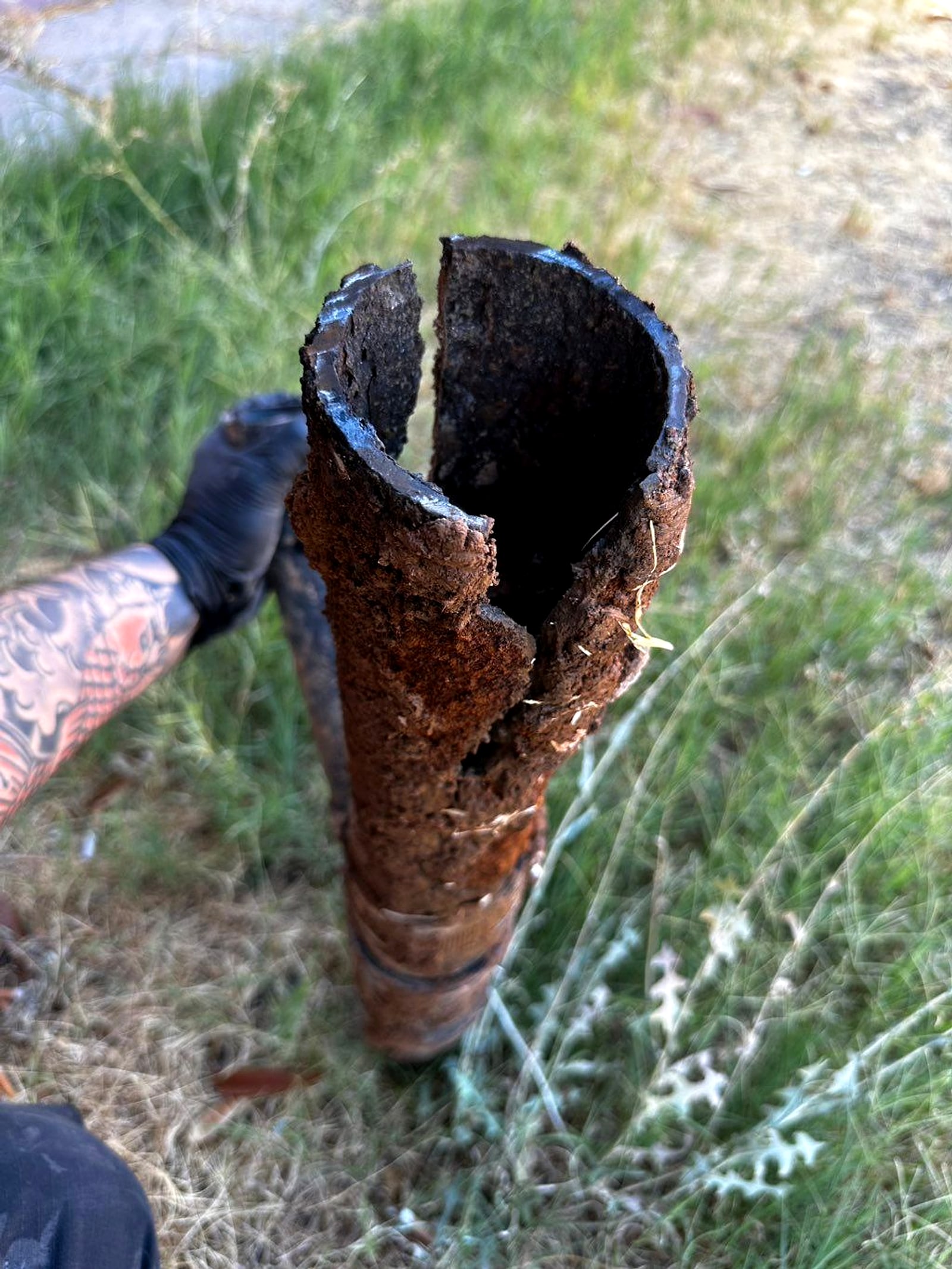 Rusted-through cast iron pipe pulled out on a sewer job